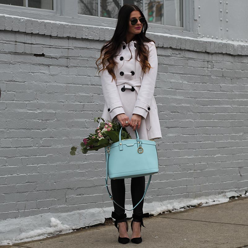 White coat and leather leggings and bow heels and Henri Bendel purse