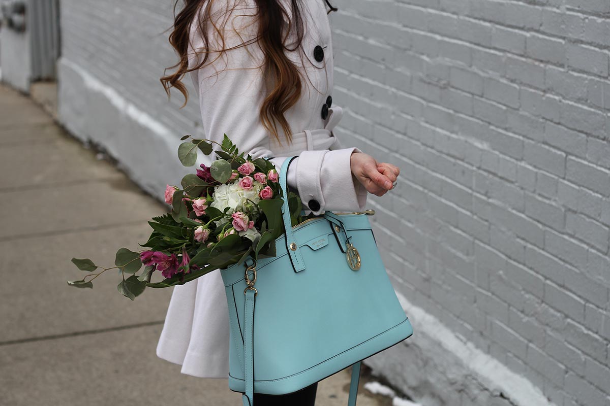 White coat and leather leggings and bow heels and Henri Bendel purse
