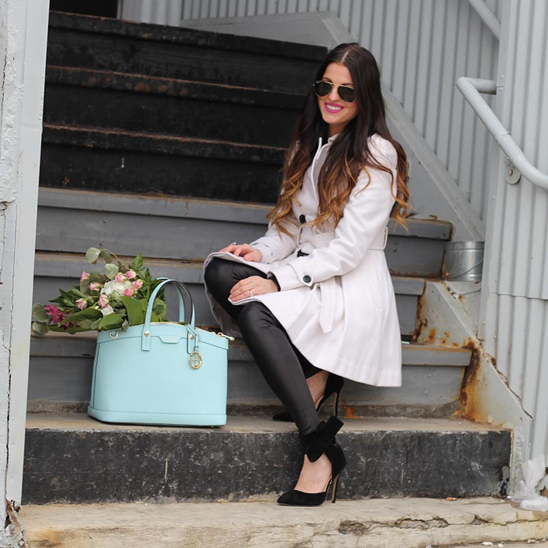 White coat and leather leggings and bow heels and Henri Bendel purse