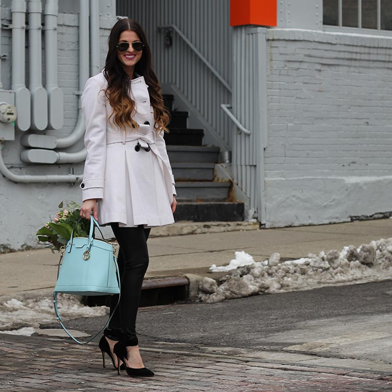 White coat and leather leggings and bow heels and Henri Bendel purse